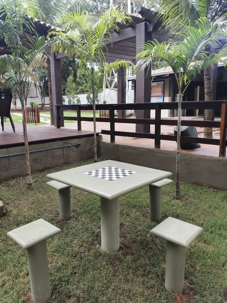 Mesa de xadrez com tabuleiro quadrado em destaque.